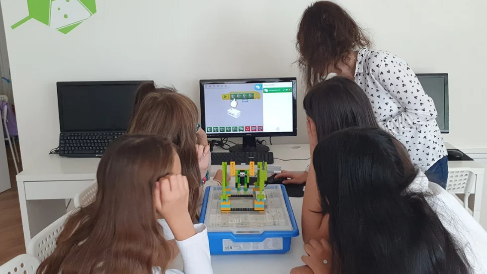 Учителка помага на своите ученици за изпълнението на STEM проект
