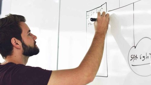 Boy writing on white board
