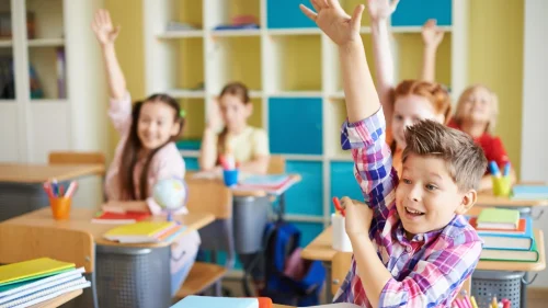 Ученици вдигат ръка и се усмихват